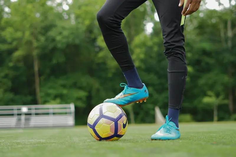 A player stopping the ball under the sole of his boot