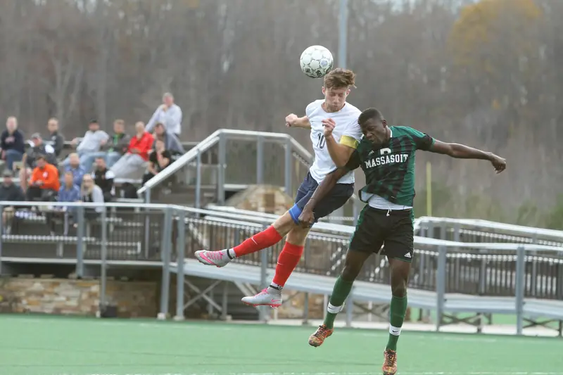 Two players jumping together to head the ball