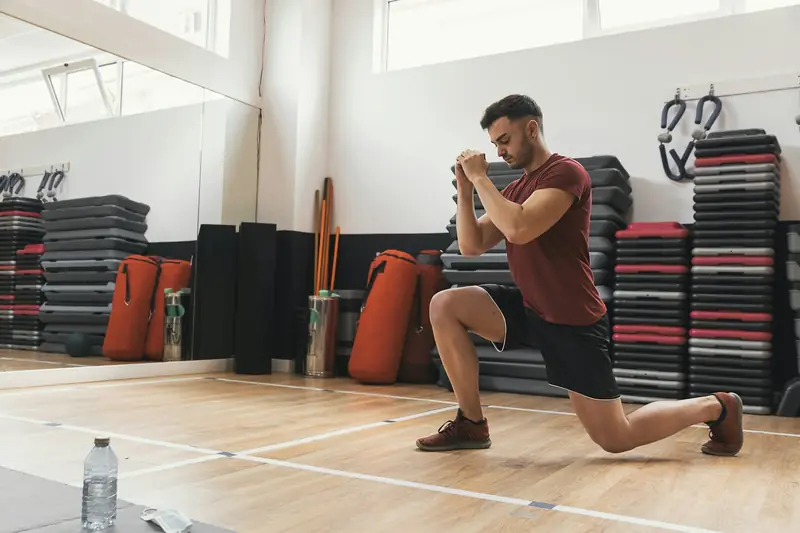 A man doing a lunge in a training studio