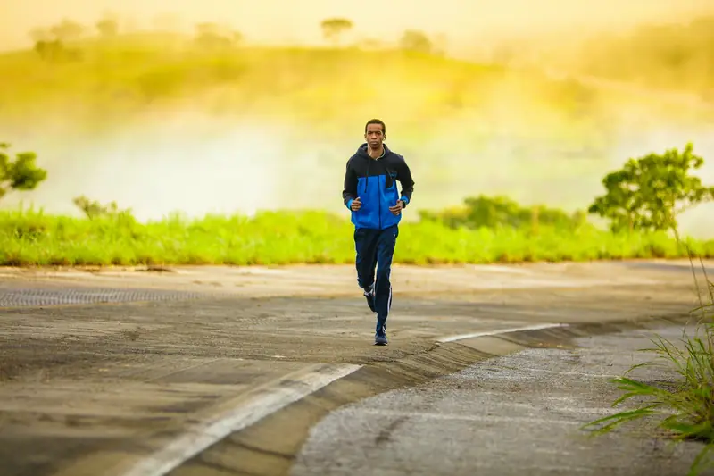 A runner jogging alone along a quiet road at sunrise