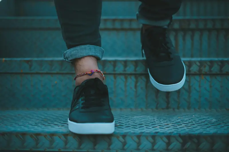 A person stepping up a flight of metal stairs