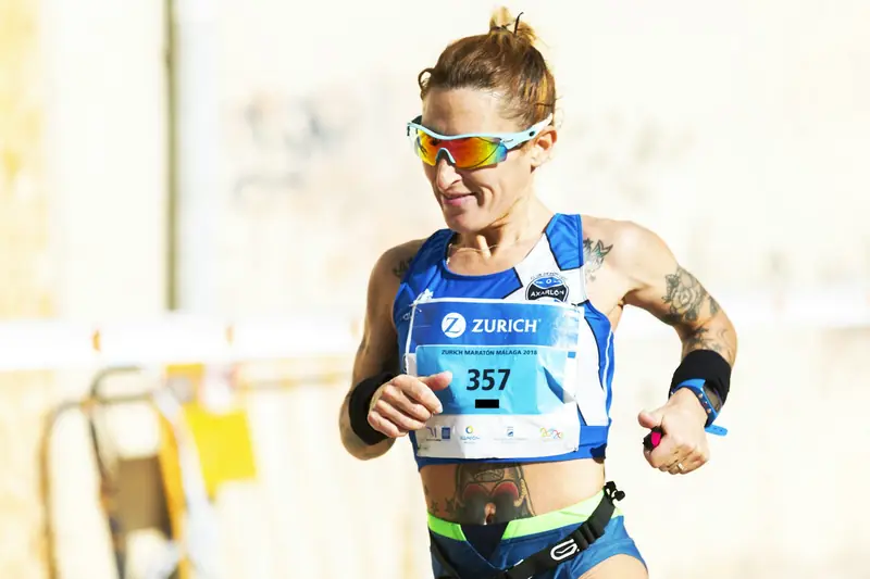 A marathon runner checking her watch late in a race