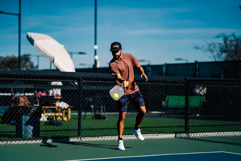 A player hitting a volley close to the net on an outdoor court