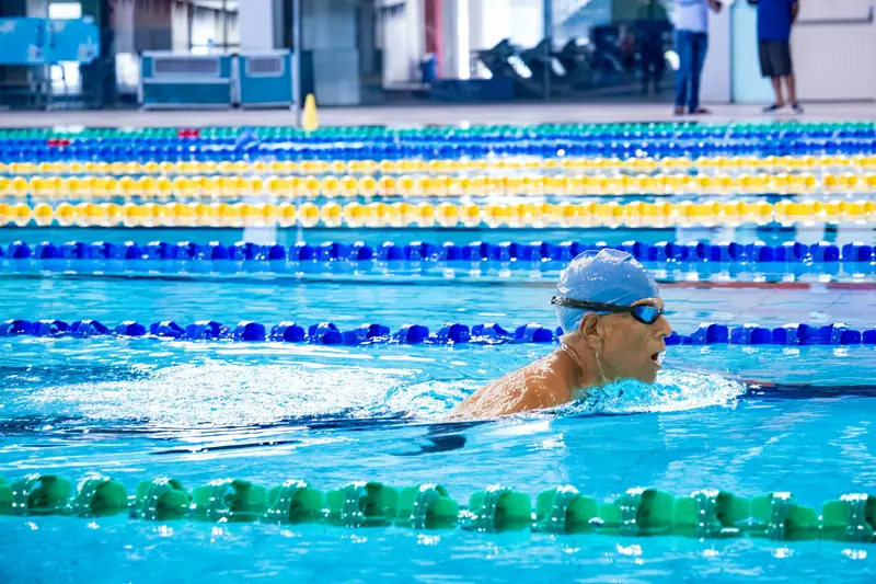 A man swimming breaststroke with his head up to breathe