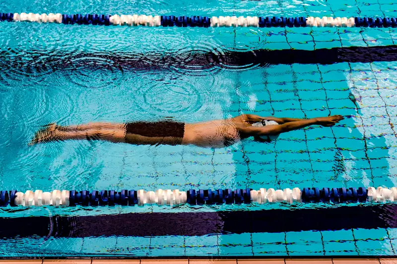 A swimmer gliding in a tight streamline along a pool lane