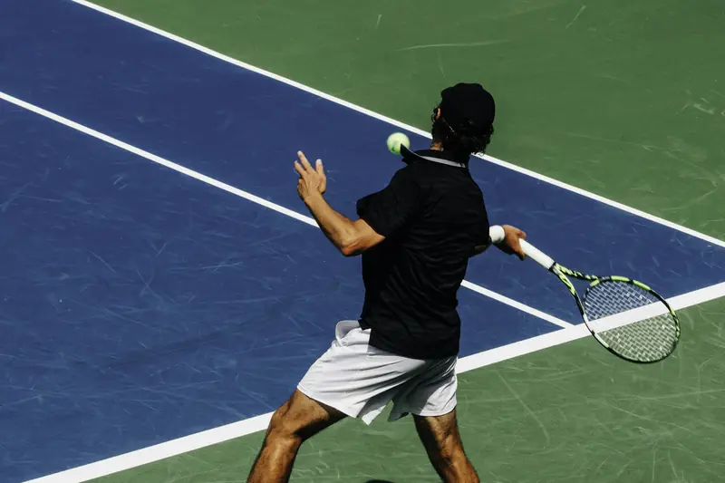 A player turning his shoulders and taking the racket back as the ball arrives