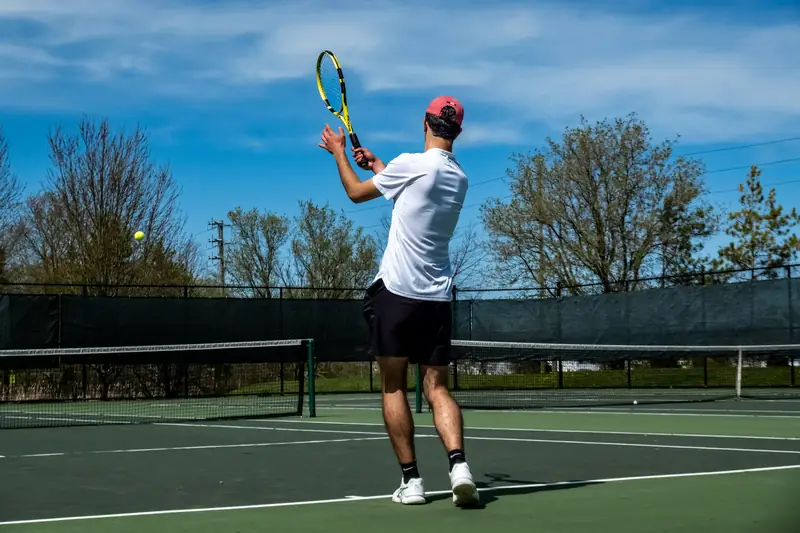 A player on an outdoor court with his racket up, waiting to return